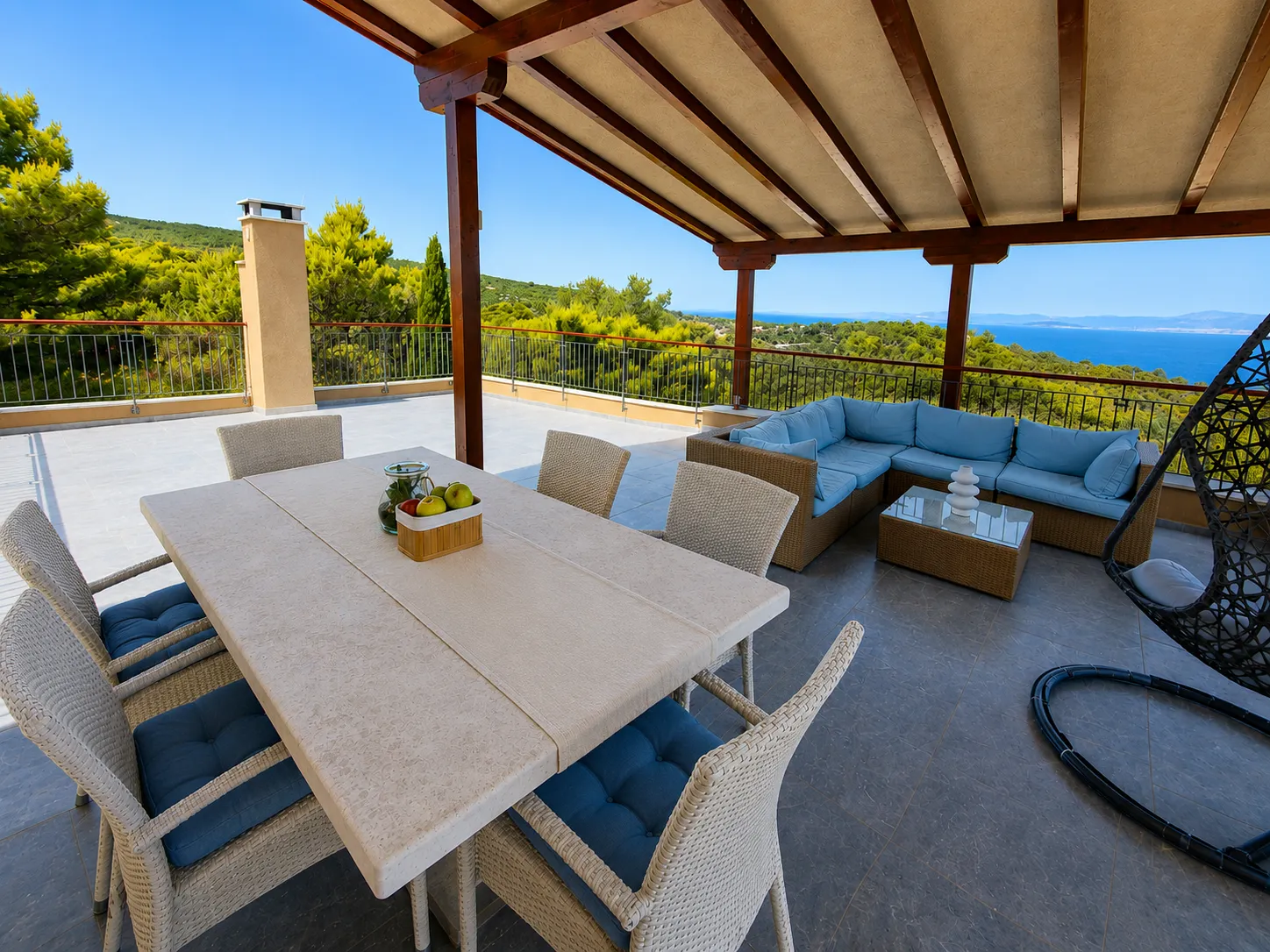 Upper terrace with dining table and sea view
