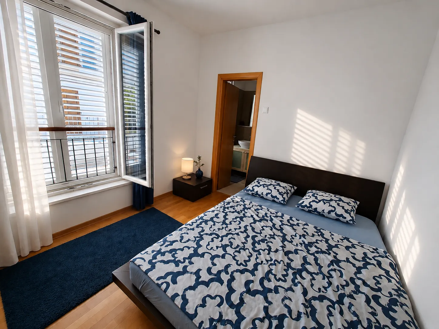 Bedroom with wooden floors and balcony